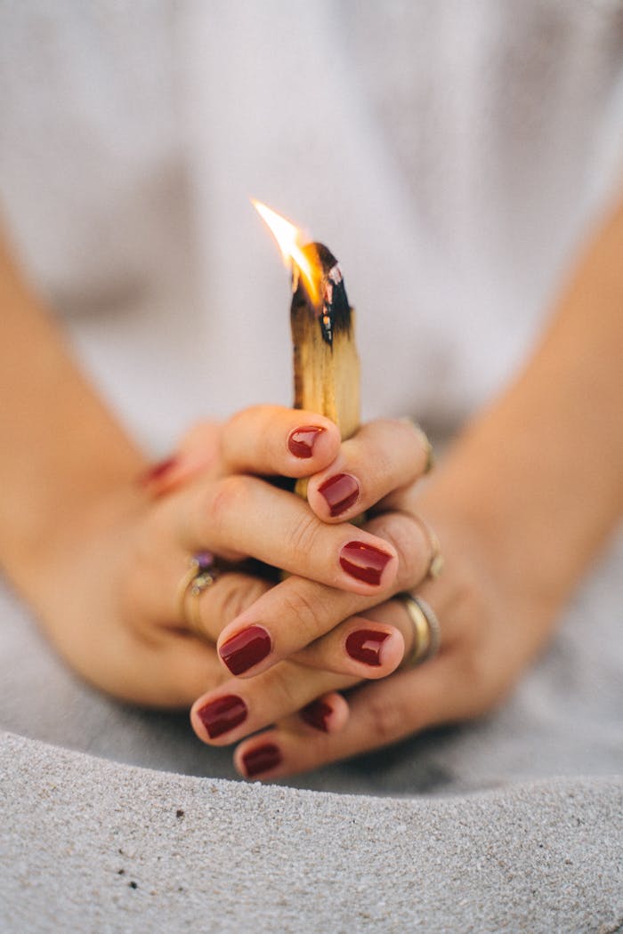 services-04 Close-up of hands holding burning Palo Santo for spiritual meditation.