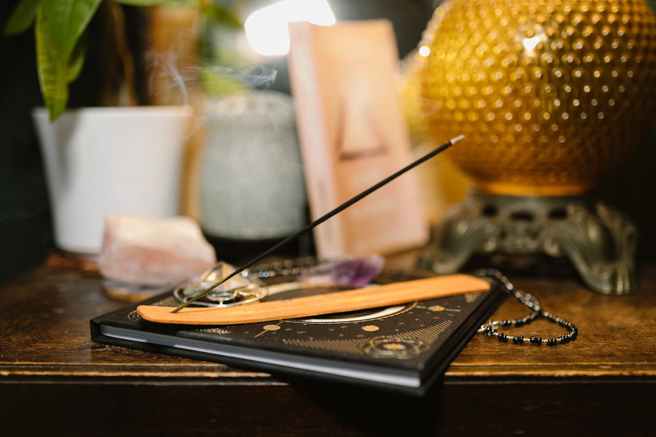 client-stories-img A tranquil setting featuring incense, crystals, and a glowing lamp for spiritual rituals.