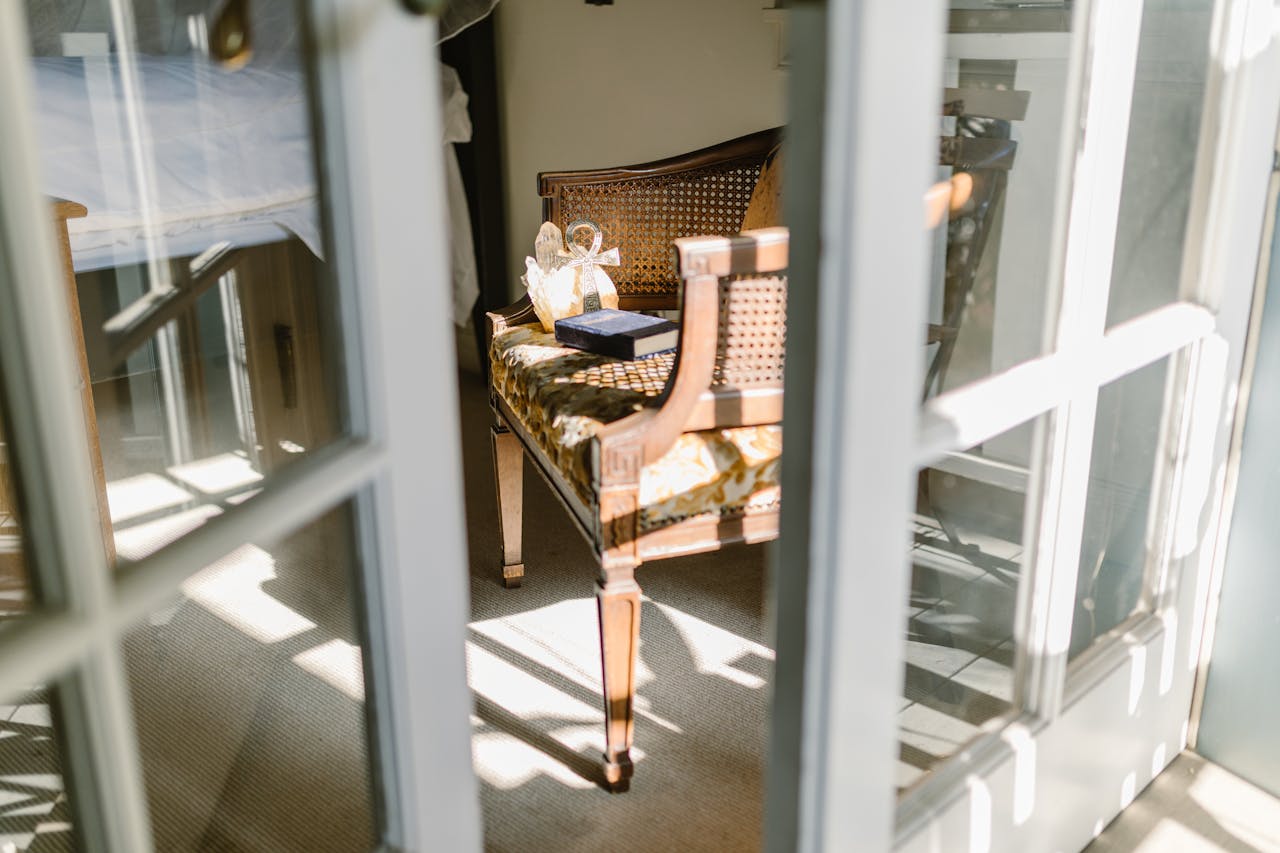 Sunlight illuminates a cozy interior with classic wooden furniture, creating a warm ambiance.